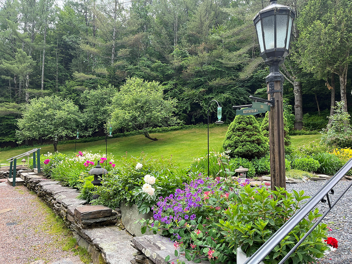 Front Garden in Summer with green lawn, trees, and flowers
